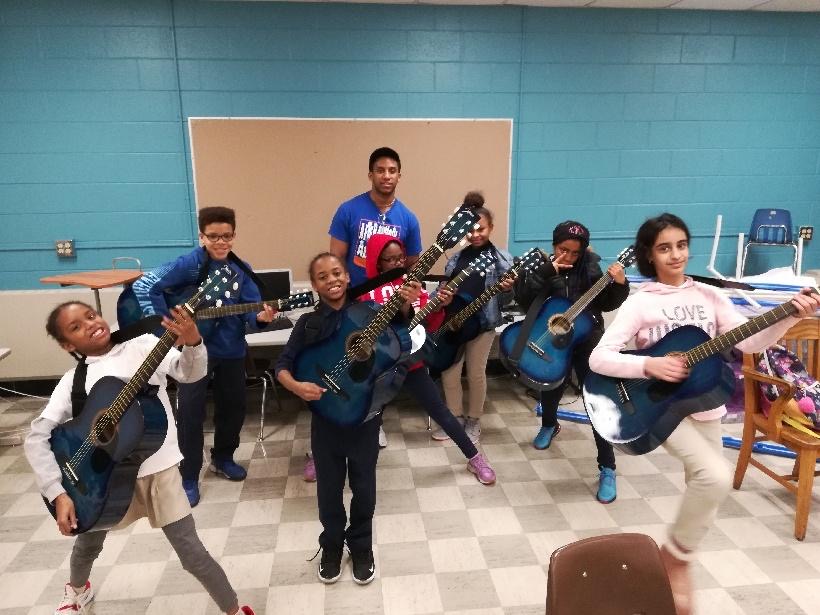 The class showing off their guitars on Graduation Day